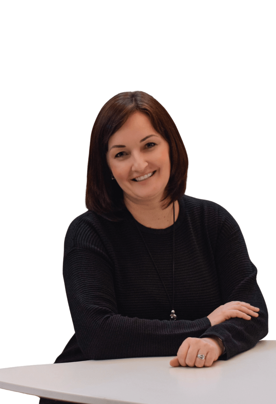 Iva Bártková, majitelka a lektorka angličtiny jazykové školy Top English. Sedí u stolu a usmívá se.